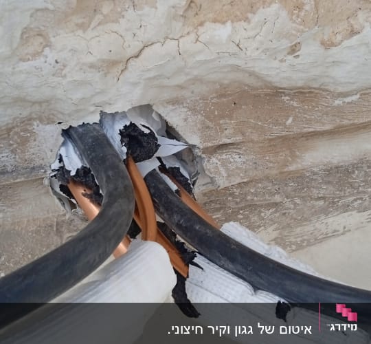 צינורות עם חומר איטום שחור בקיר